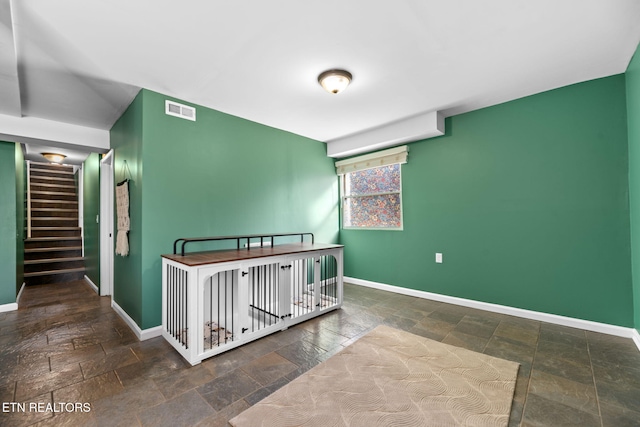 bedroom featuring stone tile floors, baseboards, and visible vents