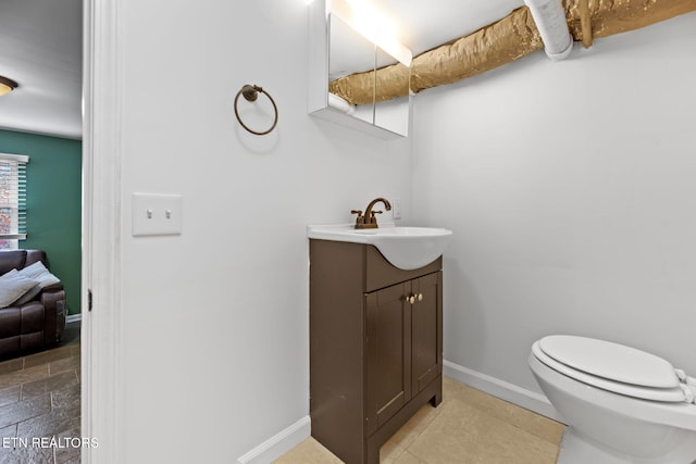 bathroom featuring baseboards, toilet, and vanity