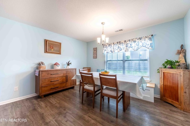 dining room featuring visible vents, dark wood finished floors, baseboards, and an inviting chandelier