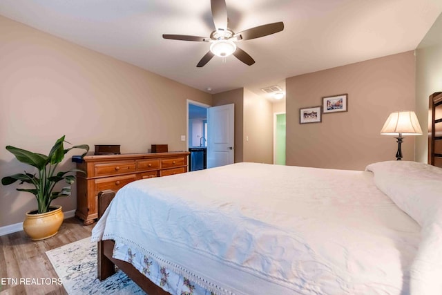 bedroom featuring a ceiling fan, baseboards, visible vents, and light wood-type flooring