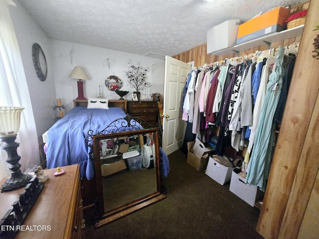 bedroom with dark carpet and a textured ceiling