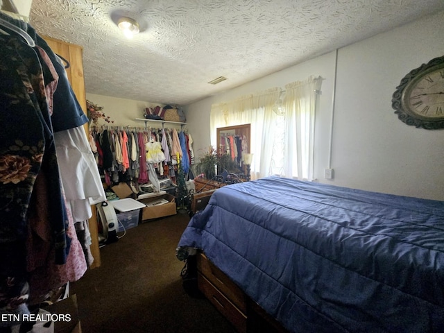 bedroom featuring carpet floors, a textured ceiling, and visible vents