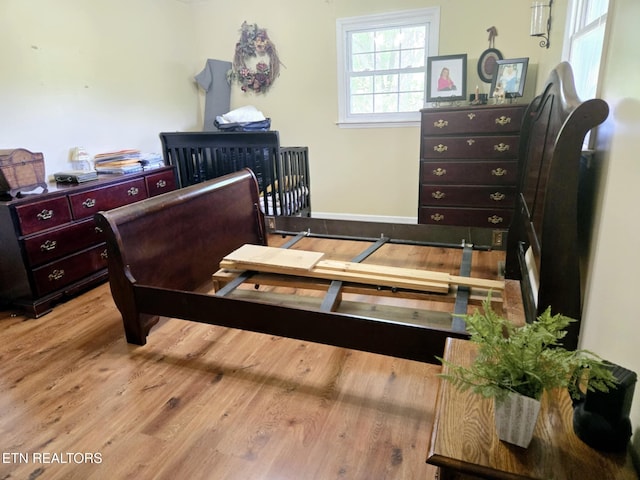 bedroom featuring wood finished floors and baseboards