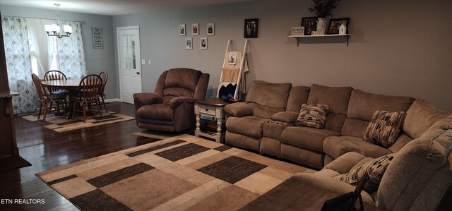 living room featuring a chandelier and dark wood finished floors