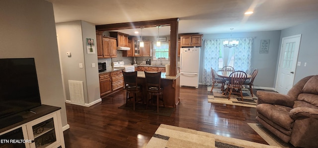 dining space with dark wood finished floors, baseboards, a chandelier, and visible vents