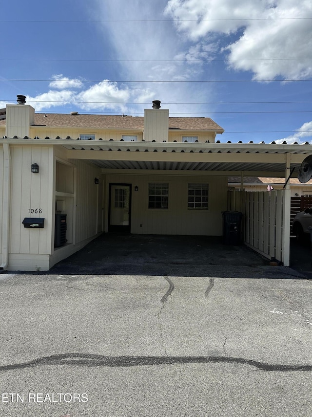 exterior space with central air condition unit, a chimney, and fence