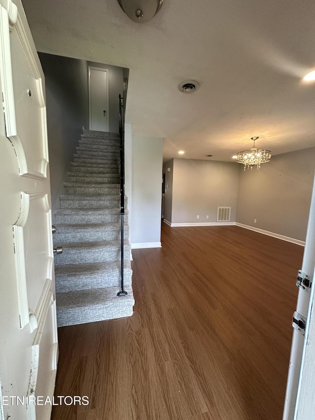 stairway featuring recessed lighting, wood finished floors, visible vents, baseboards, and a chandelier