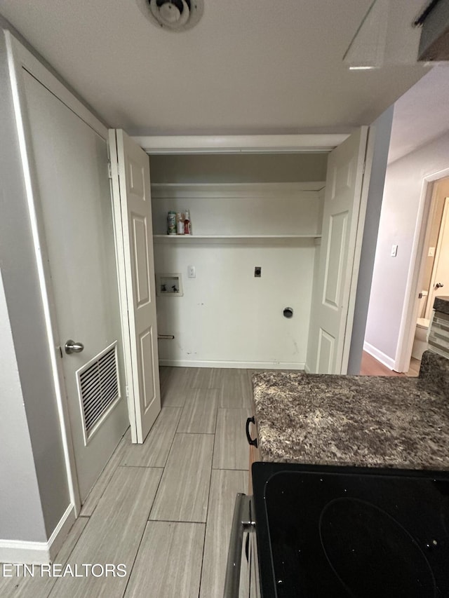 kitchen with wood finish floors, visible vents, and baseboards