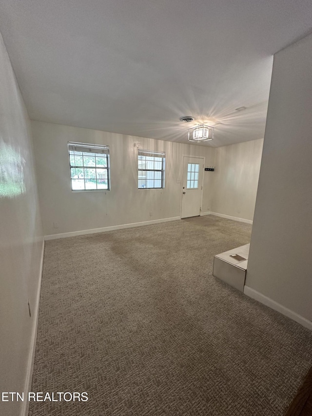 carpeted empty room with baseboards