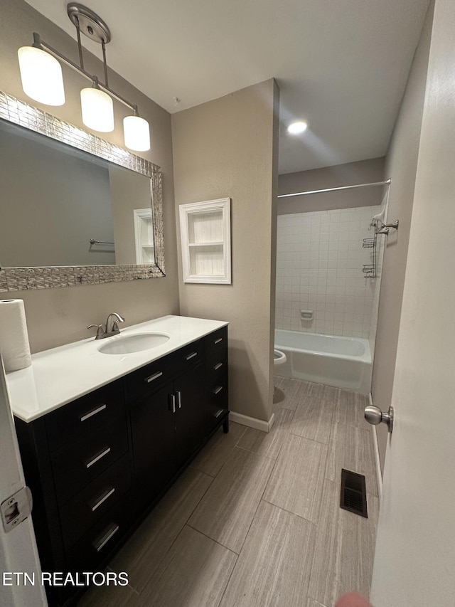 full bath with wood tiled floor, visible vents, toilet, vanity, and baseboards