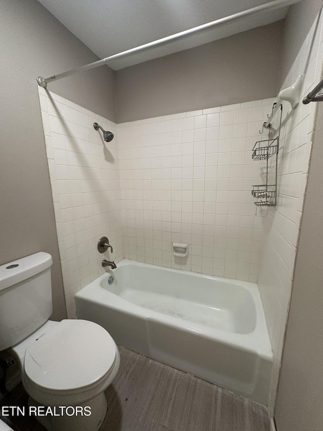 bathroom with bathing tub / shower combination, wood finished floors, and toilet