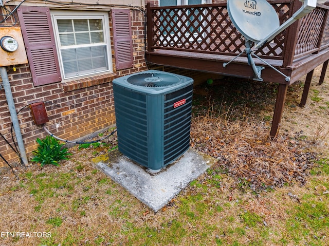 exterior details featuring electric meter, brick siding, and cooling unit