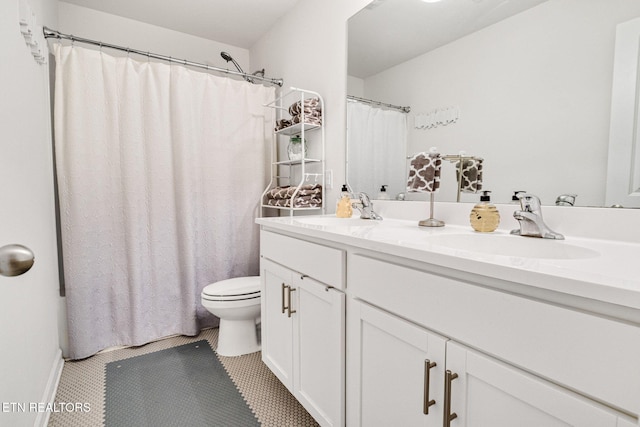 bathroom with double vanity, toilet, tile patterned flooring, and a sink