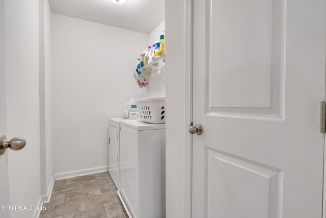 laundry area with baseboards, laundry area, and washer and clothes dryer
