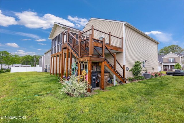 back of property with a deck, a yard, stairway, fence, and central air condition unit