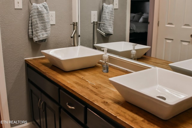 bathroom featuring a textured wall and vanity