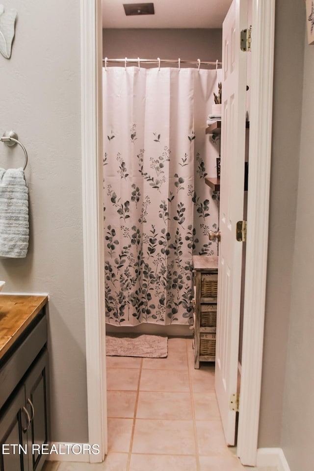 full bath featuring tile patterned flooring, vanity, and a shower with shower curtain