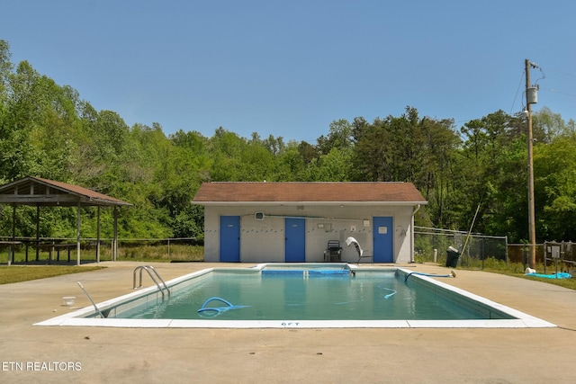 pool with fence and a patio