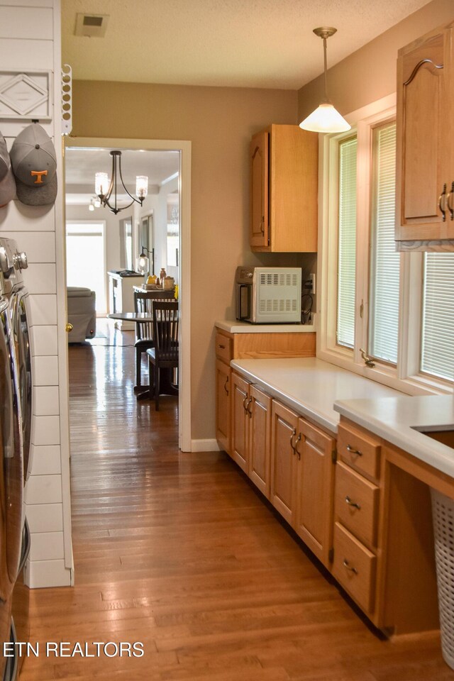 kitchen with visible vents, a chandelier, light countertops, wood finished floors, and hanging light fixtures
