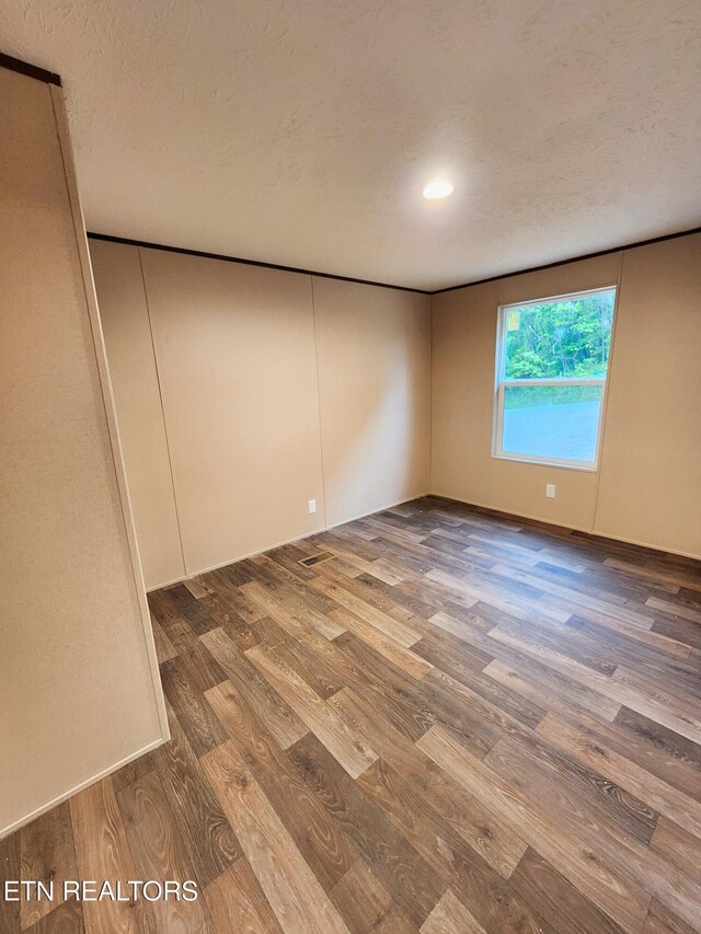 unfurnished room featuring a textured ceiling, recessed lighting, and wood finished floors