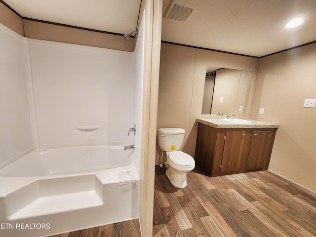 bathroom with shower / tub combination, vanity, toilet, wood finished floors, and visible vents