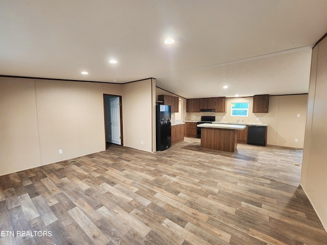 kitchen featuring light wood-style floors, light countertops, black appliances, and open floor plan