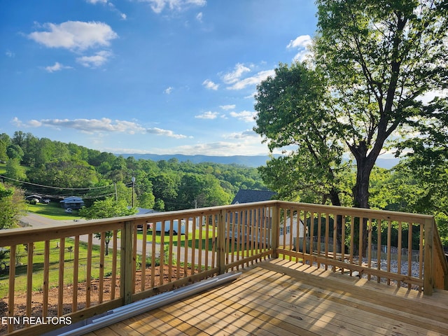 wooden terrace featuring a wooded view