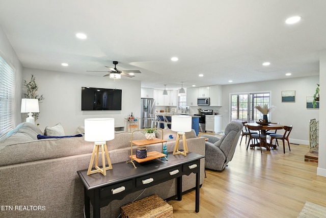living area featuring light wood-type flooring, recessed lighting, and a ceiling fan