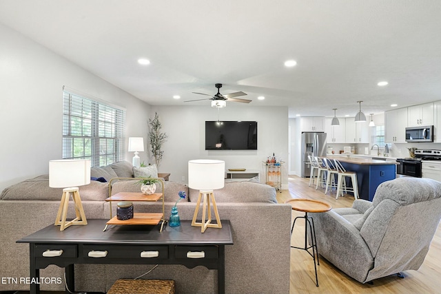 living room featuring ceiling fan, light wood-type flooring, and recessed lighting