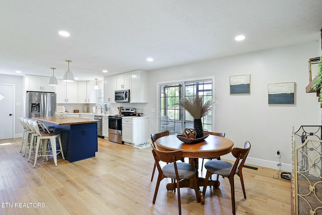 dining space featuring baseboards, visible vents, light wood-style floors, and recessed lighting