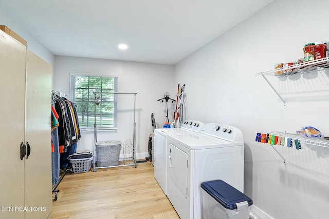 clothes washing area featuring washing machine and clothes dryer, baseboards, light wood-type flooring, recessed lighting, and laundry area