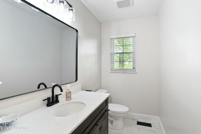 half bathroom with toilet, marble finish floor, visible vents, and baseboards