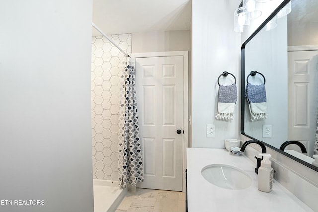 bathroom featuring marble finish floor, a shower stall, and vanity