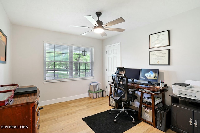 office area with baseboards, a ceiling fan, and light wood finished floors