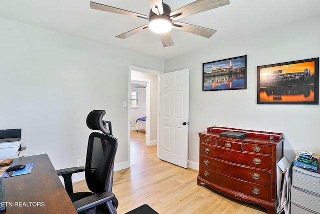 office featuring baseboards, light wood-type flooring, and a ceiling fan