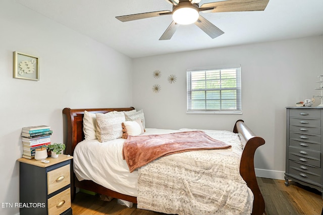 bedroom with wood finished floors, a ceiling fan, and baseboards