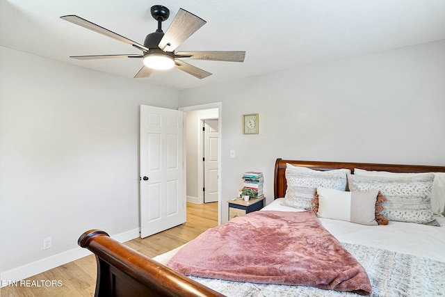 bedroom with a ceiling fan, baseboards, and light wood-style floors