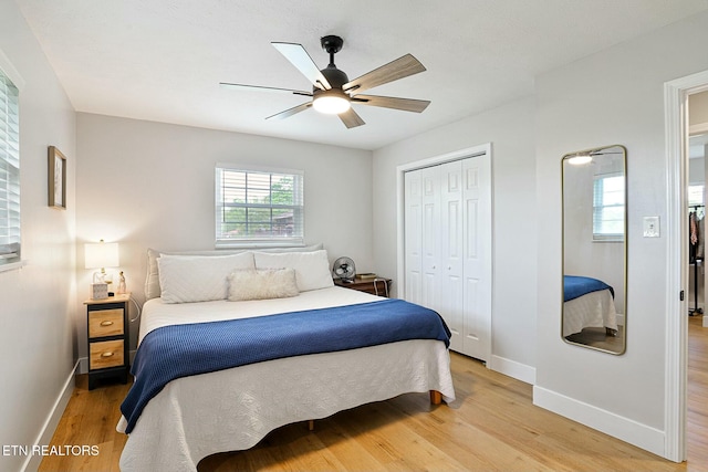 bedroom featuring ceiling fan, light wood-type flooring, a closet, and baseboards