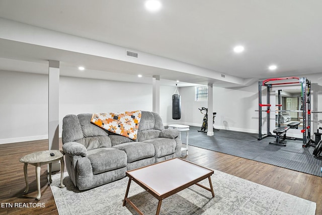 living area with wood finished floors, visible vents, and baseboards