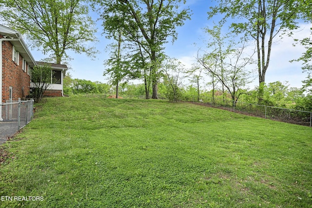 view of yard with fence and a sunroom