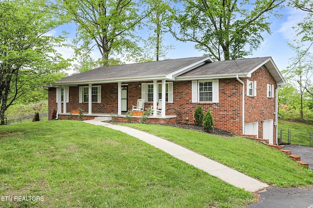 ranch-style home with a garage, brick siding, fence, and covered porch