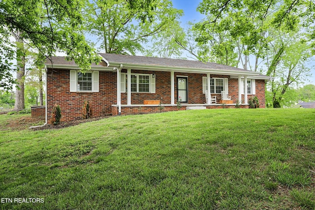ranch-style house with covered porch, brick siding, and a front yard