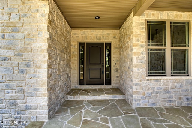 doorway to property featuring brick siding
