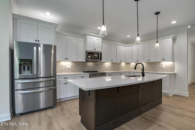 kitchen featuring stainless steel appliances, a sink, light wood-type flooring, white cabinetry, and recessed lighting
