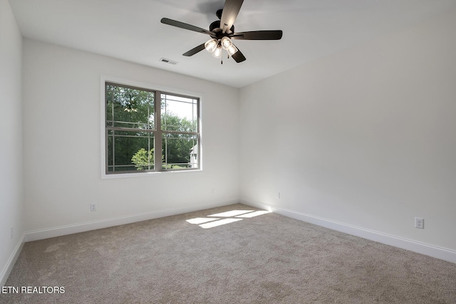 empty room featuring carpet floors, baseboards, and ceiling fan