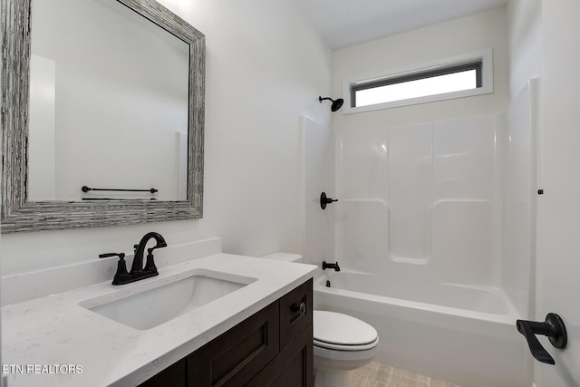 bathroom featuring toilet, vanity, and bathing tub / shower combination