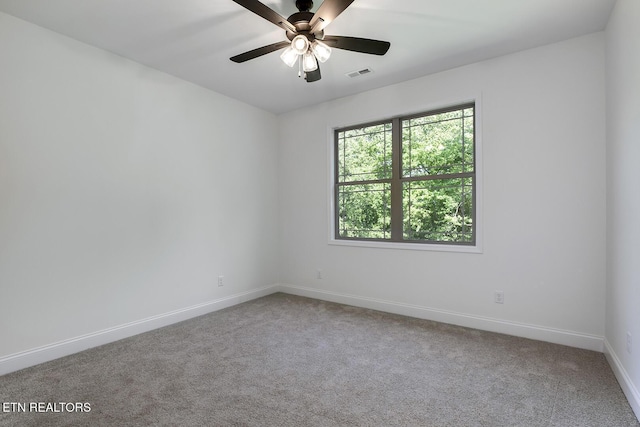 carpeted empty room with baseboards and a ceiling fan