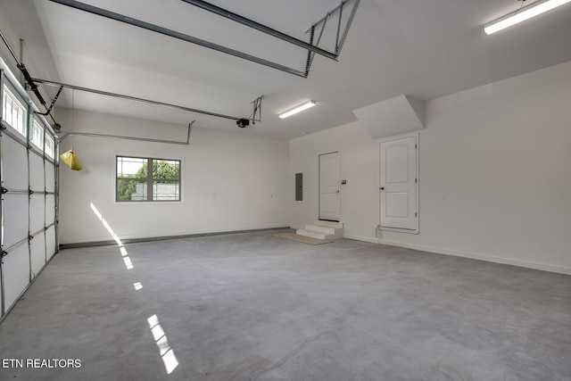 garage with electric panel, a garage door opener, and baseboards
