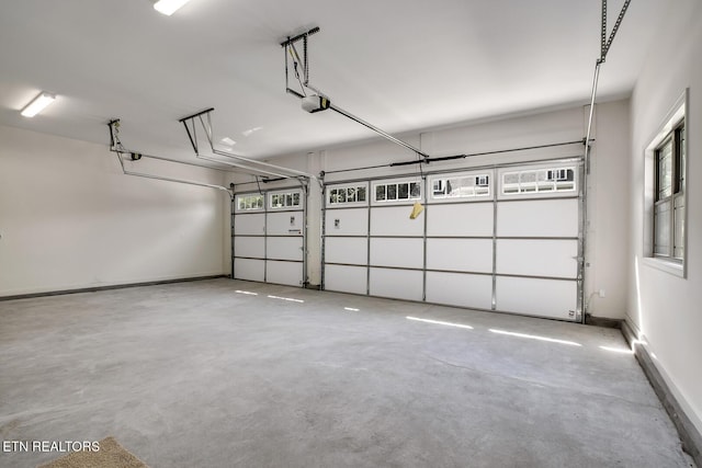 garage featuring a garage door opener and baseboards