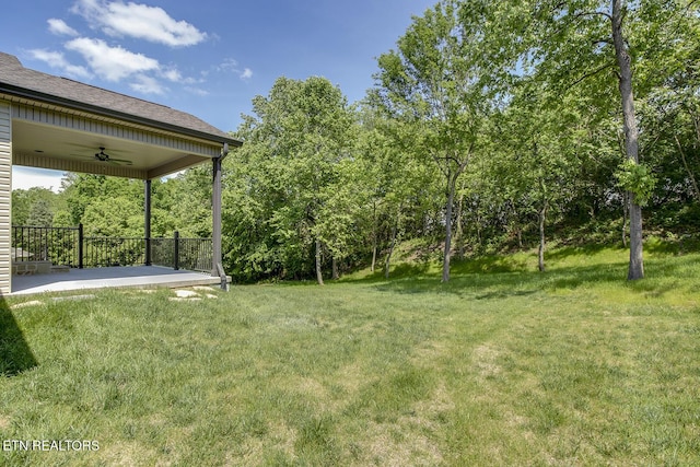 view of grassy yard featuring ceiling fan and a patio area
